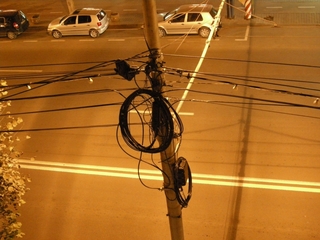 some electric cable on a pole in a street by night